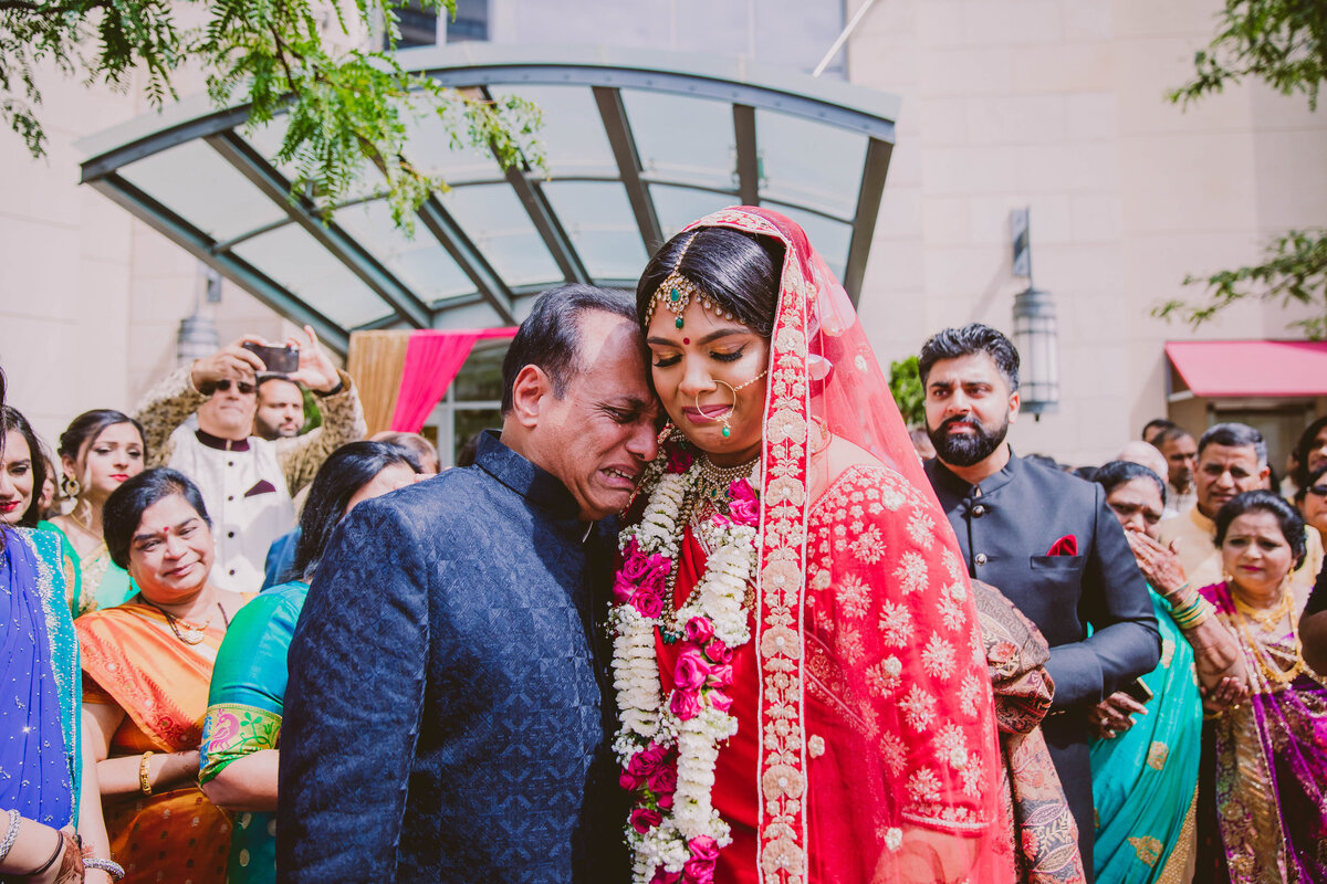 Indian bride hugging her crying father during the vidai after the hindu wedding ceremony