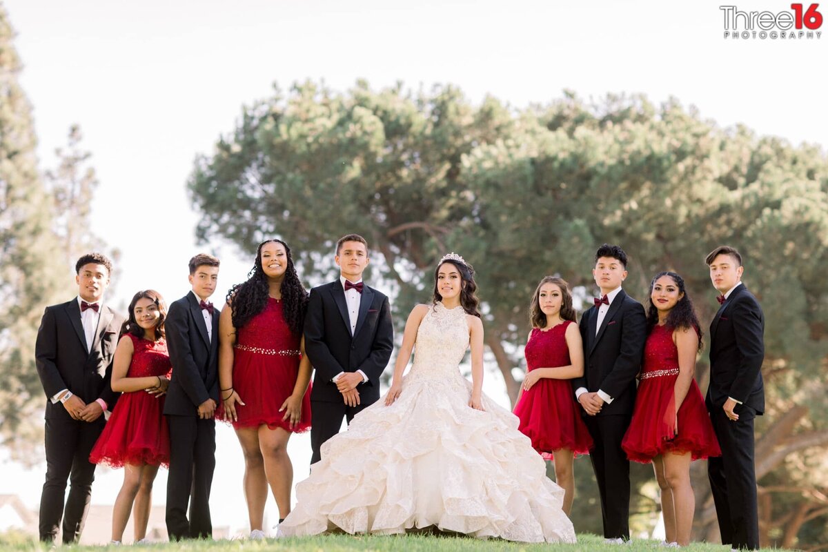 Young men and women pose with the young lady who is celebrating her quinceanera