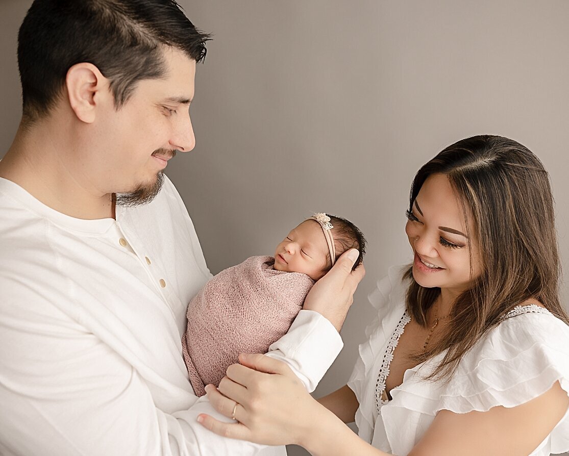 mom and dad holding baby girl in hillsboro studio