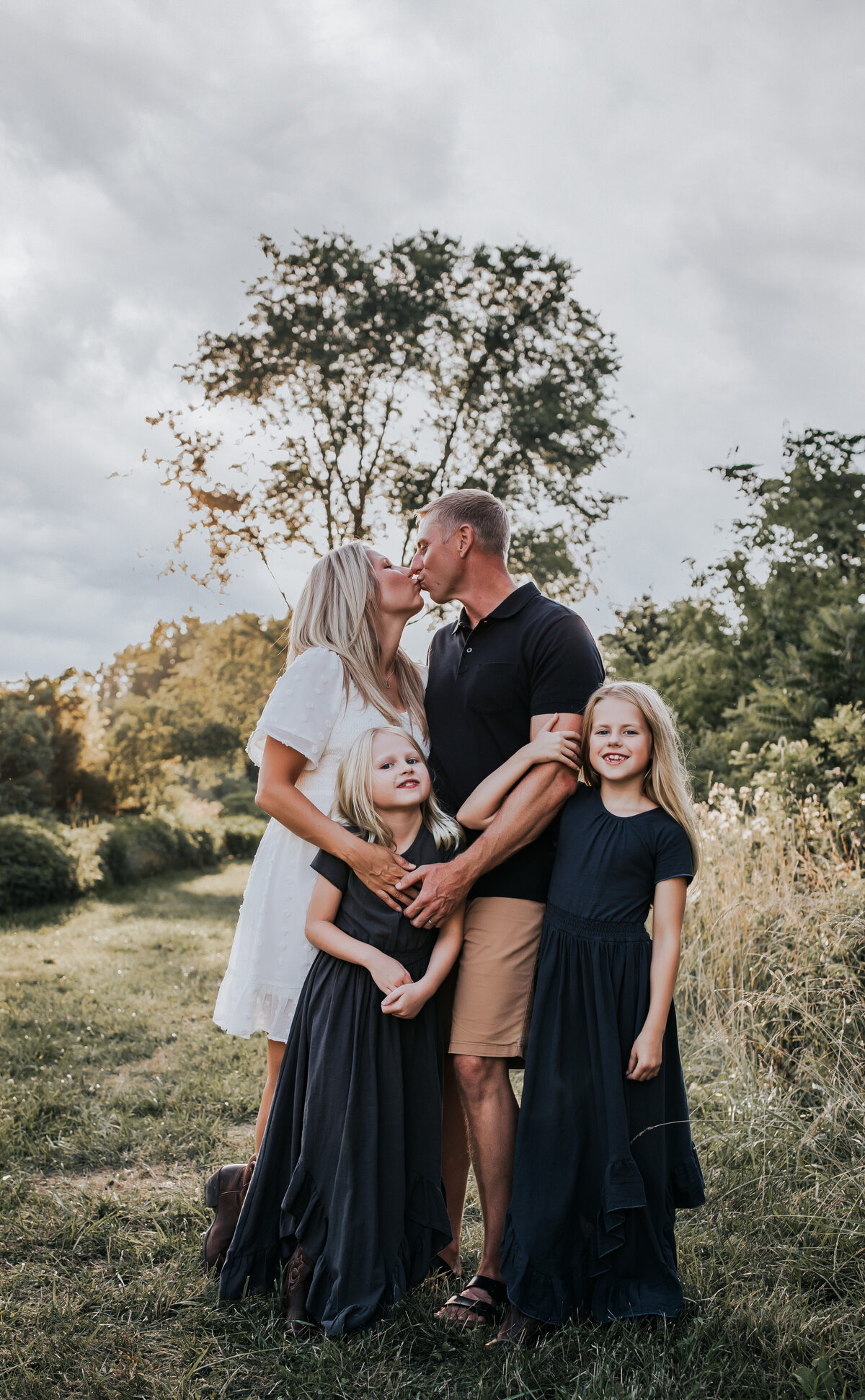 parents kissing, kids looking at the camera at  the field at White Sands New Mexico