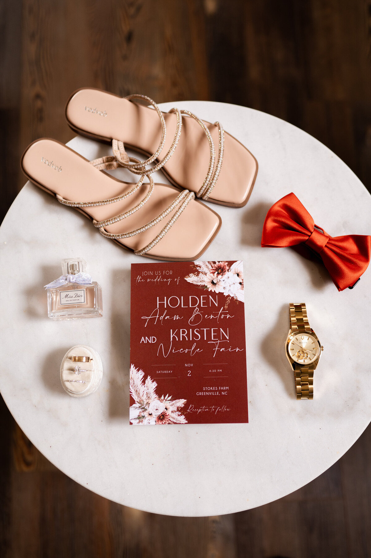 A flat day detail shot of wedding invitations and accessories taken at Stokes Family Farm in Greenville, North Carolina.