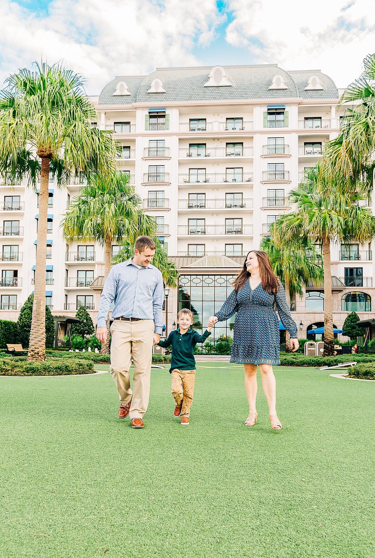 Family of three walking and holding hands at Disney's Riviera  Resort