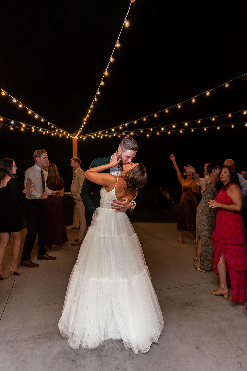Bride and groom share a kiss after their first dance during their wedding reception.