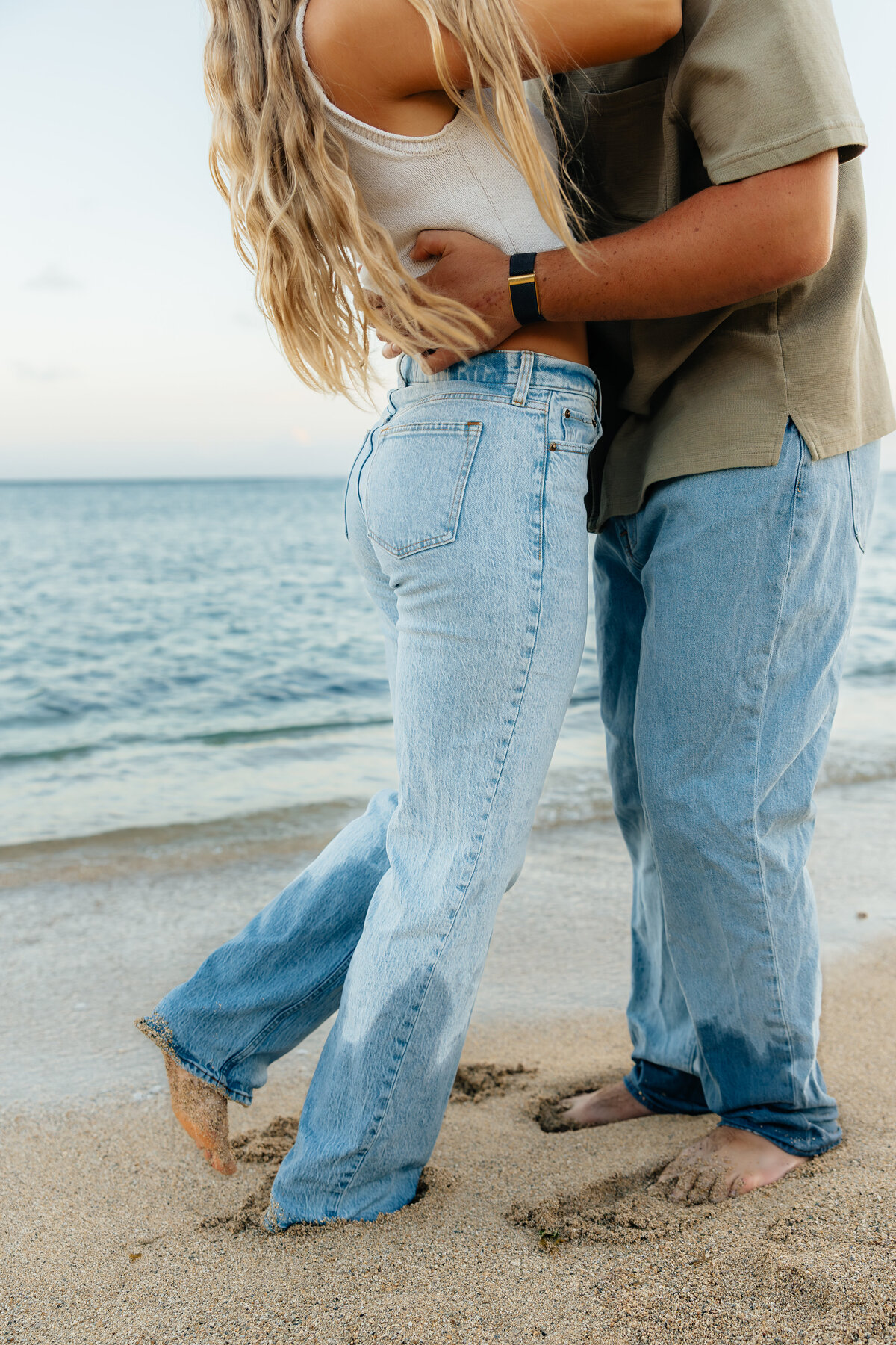 Close-up detail photo of a couple’s feet in the sand during an Oahu beach photoshoot.