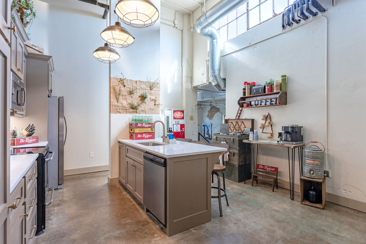 Fully stocked kitchen with island in this 2-bedroom, 2-bathroom vacation rental condo for four guests in the historic Behrens building with free parking, free wifi, vintage decor, and easy access to Baylor University, Magnolia Silos, and Cameron Park Zoo in downtown Waco, TX.