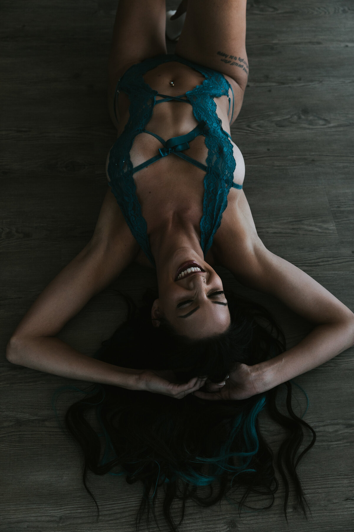 woman laying on the floor with her hands in her hair and she is wearing lingerie