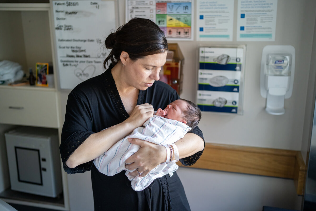 Mom rocking baby in hospital room in Boston MA