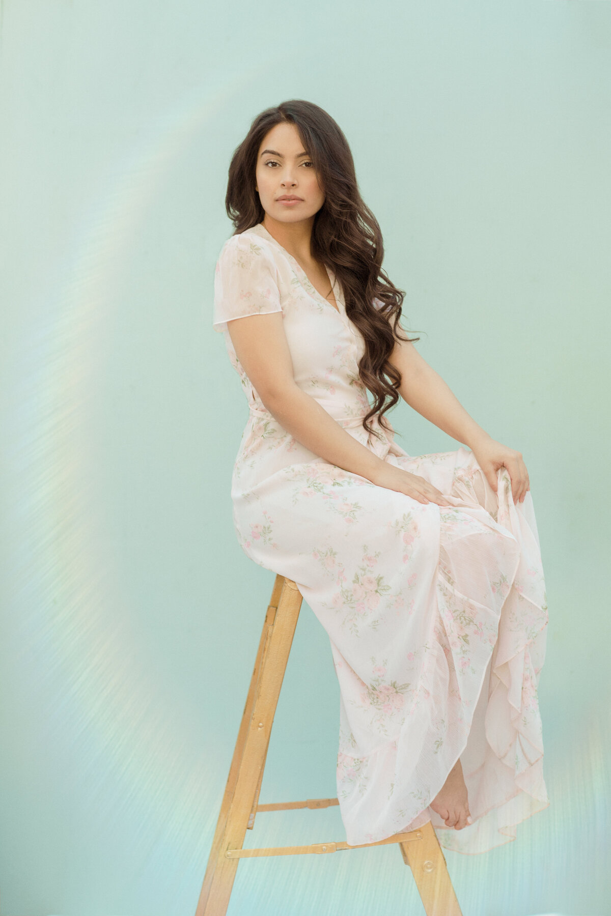Portrait Photo Of Young Woman In White Dress Sitting On a Stool Los Angeles