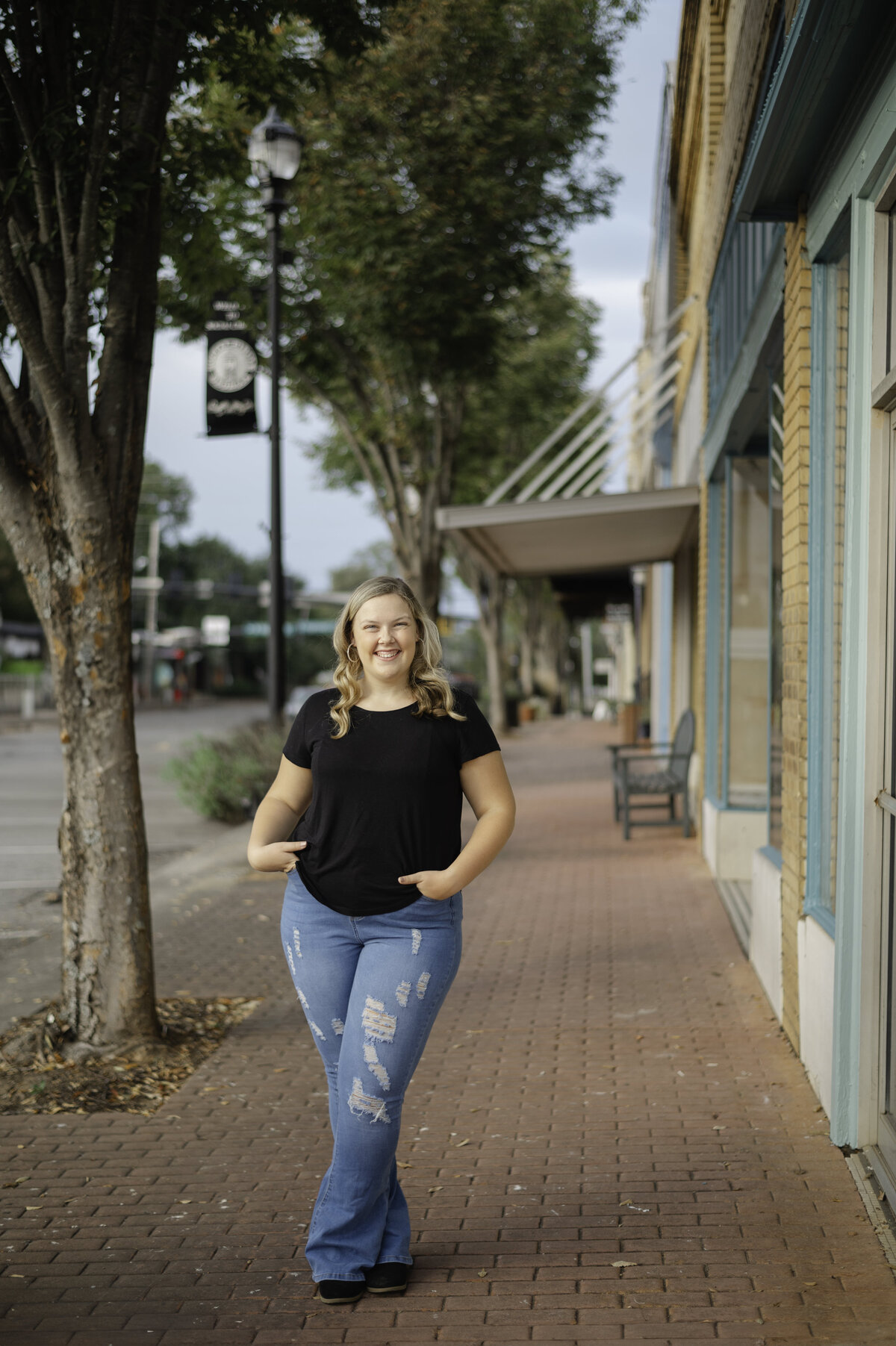 Blonde high school senior smiles and poses in downtown Social Circle