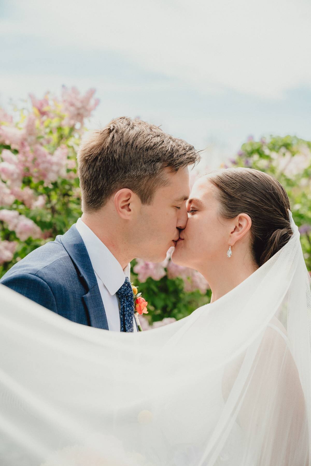 bride and groom share a kiss in the brooklyn botanical gardens