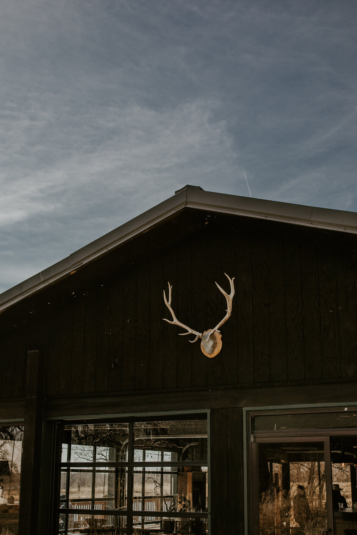 White antlers hang in front of a clubhouse set against a blue sky.
