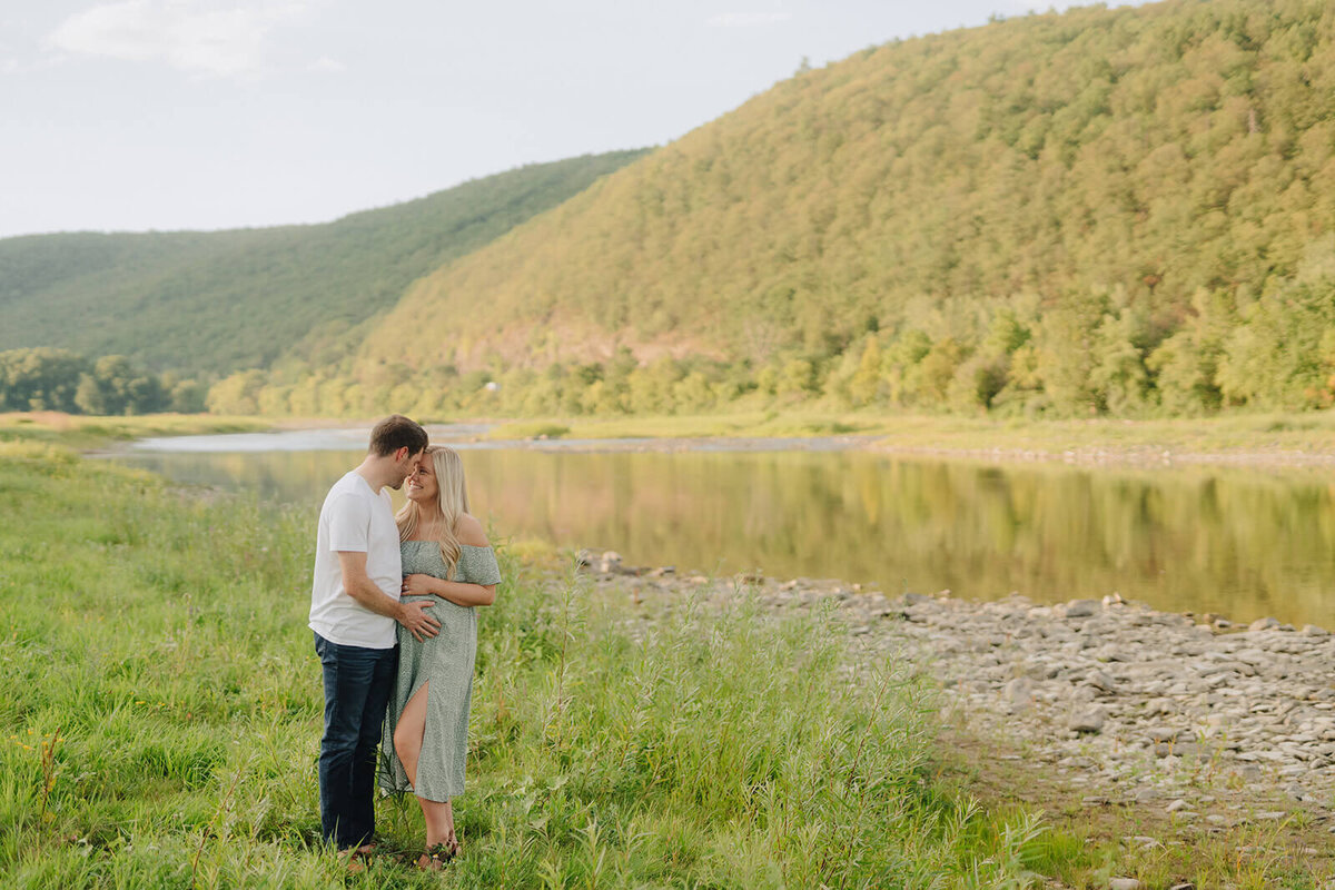 Couple sitting on sofa looking at newborn baby at Finger Lakes, New York