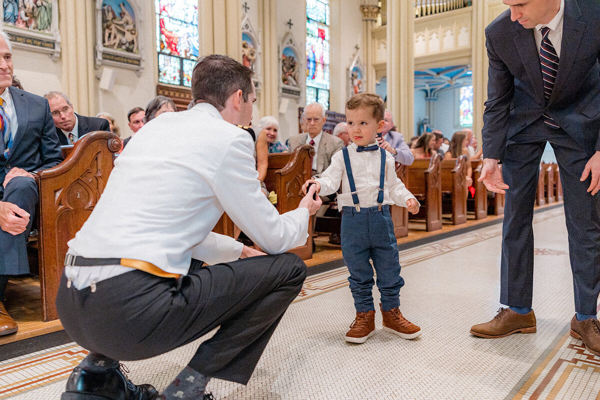 Boy toddler ring bearer talking to man