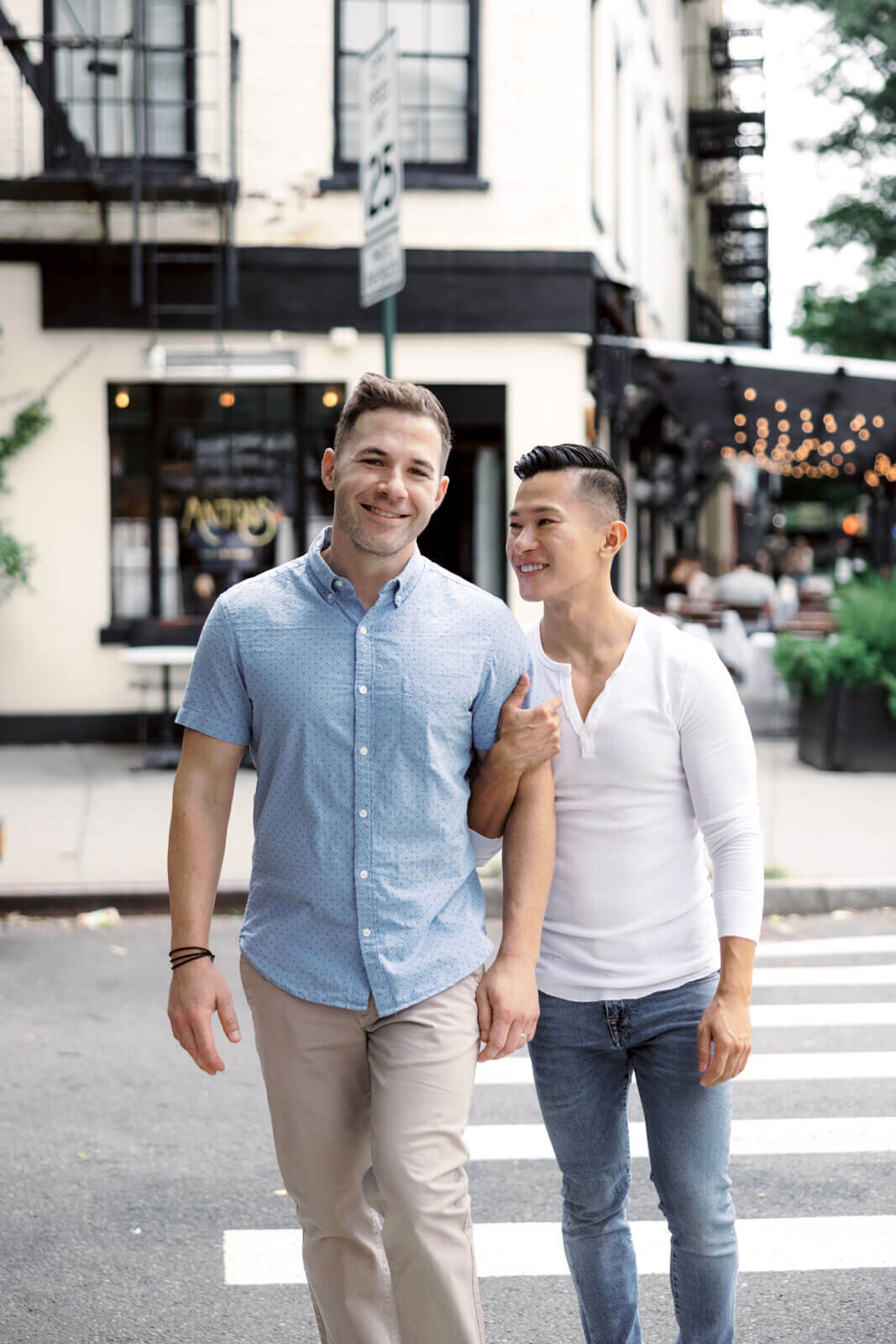 The engaged man is clinging to his fiancé's arm while crossing the street in West Village, NYC. Image by Jenny Fu Studio