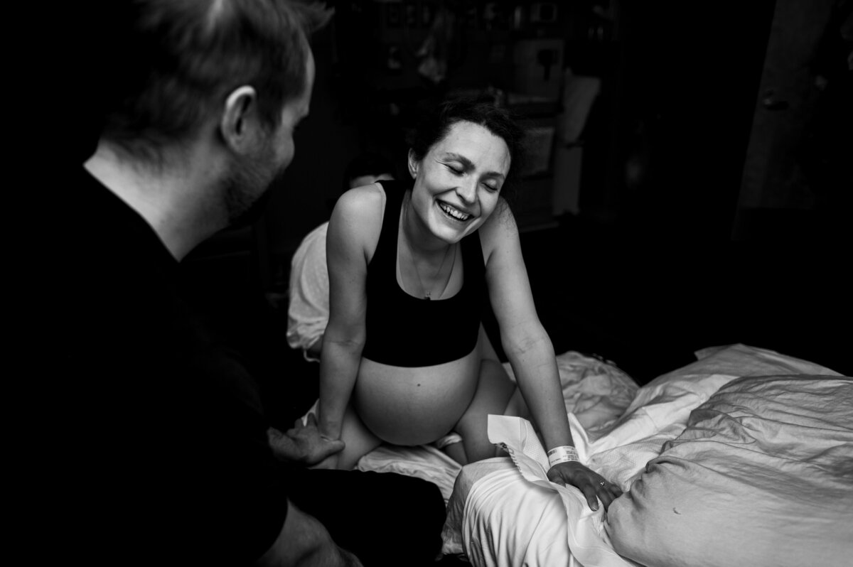 Twin birth mom smiling through contractions at her unmedicated hospital birth.