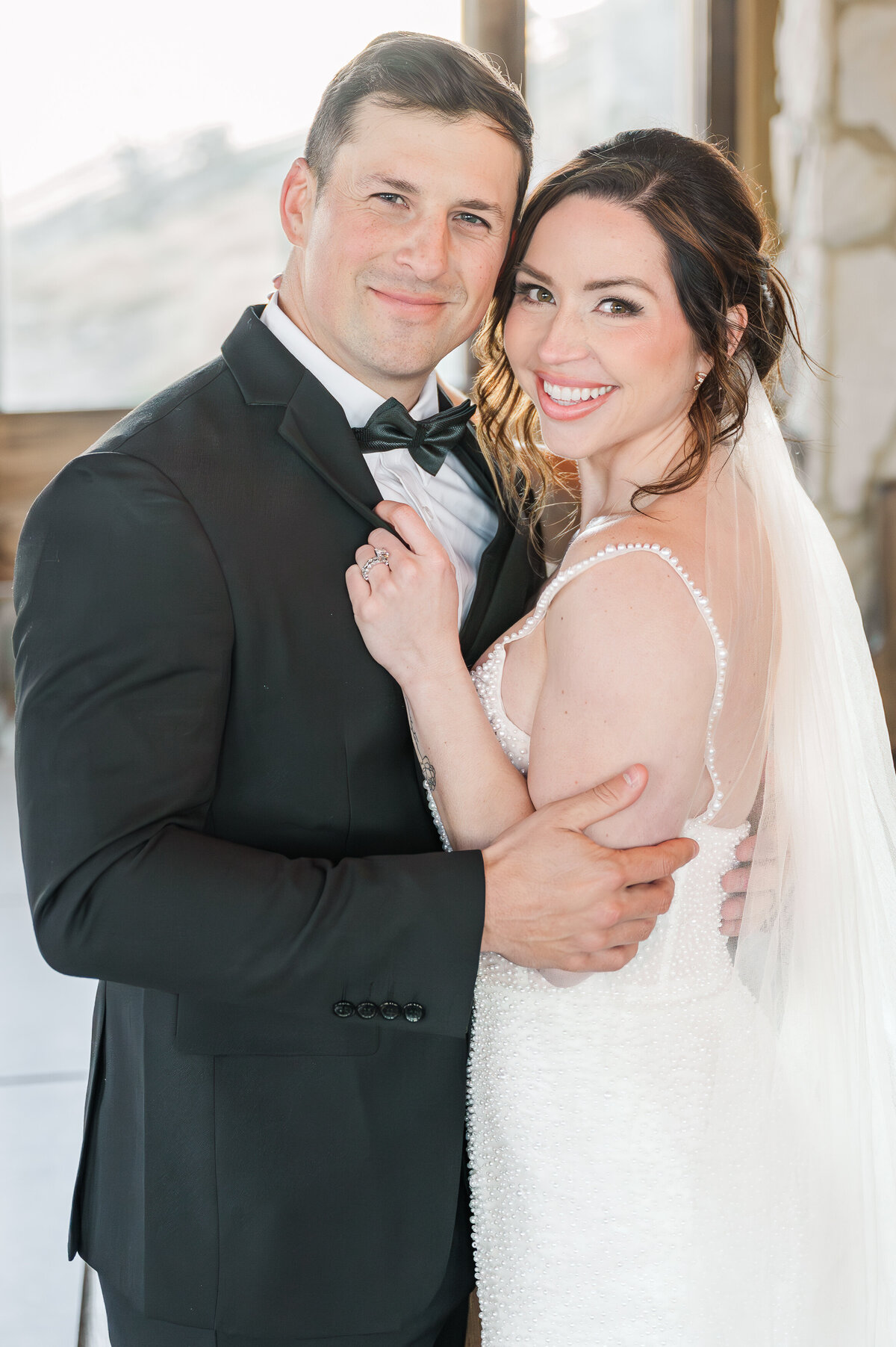 A happy married couple in a white lace dress and all black tux after their wedding ceremony at The Cliffs of Glassy Mountain at sunset enjoying their Raleigh wedding photography session with JoLynn Photography