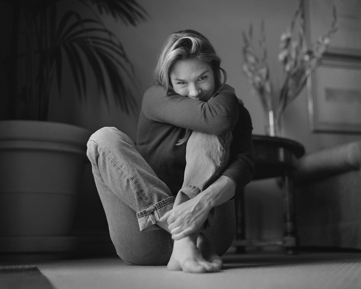 A woman sitting with her arms around her knees