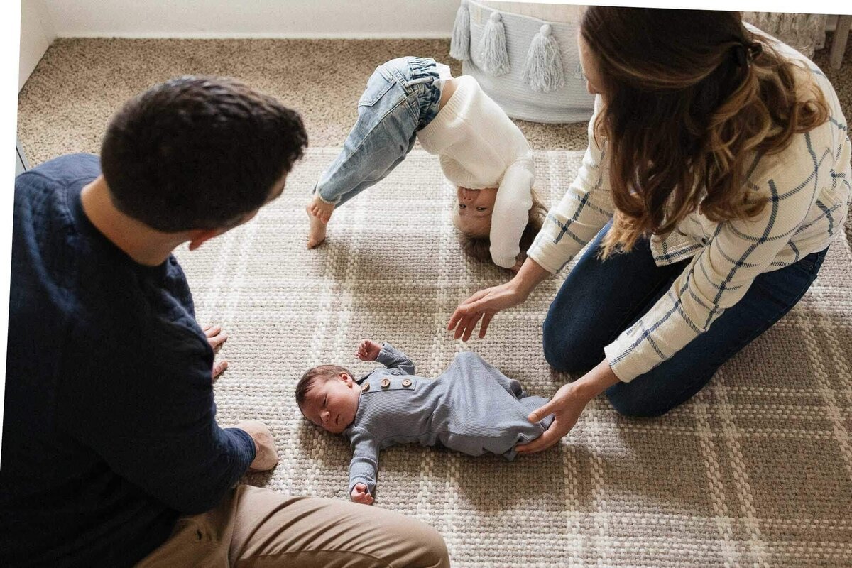 Parents and sibling gather around their newborn during a cozy family photography session in Cleveland.