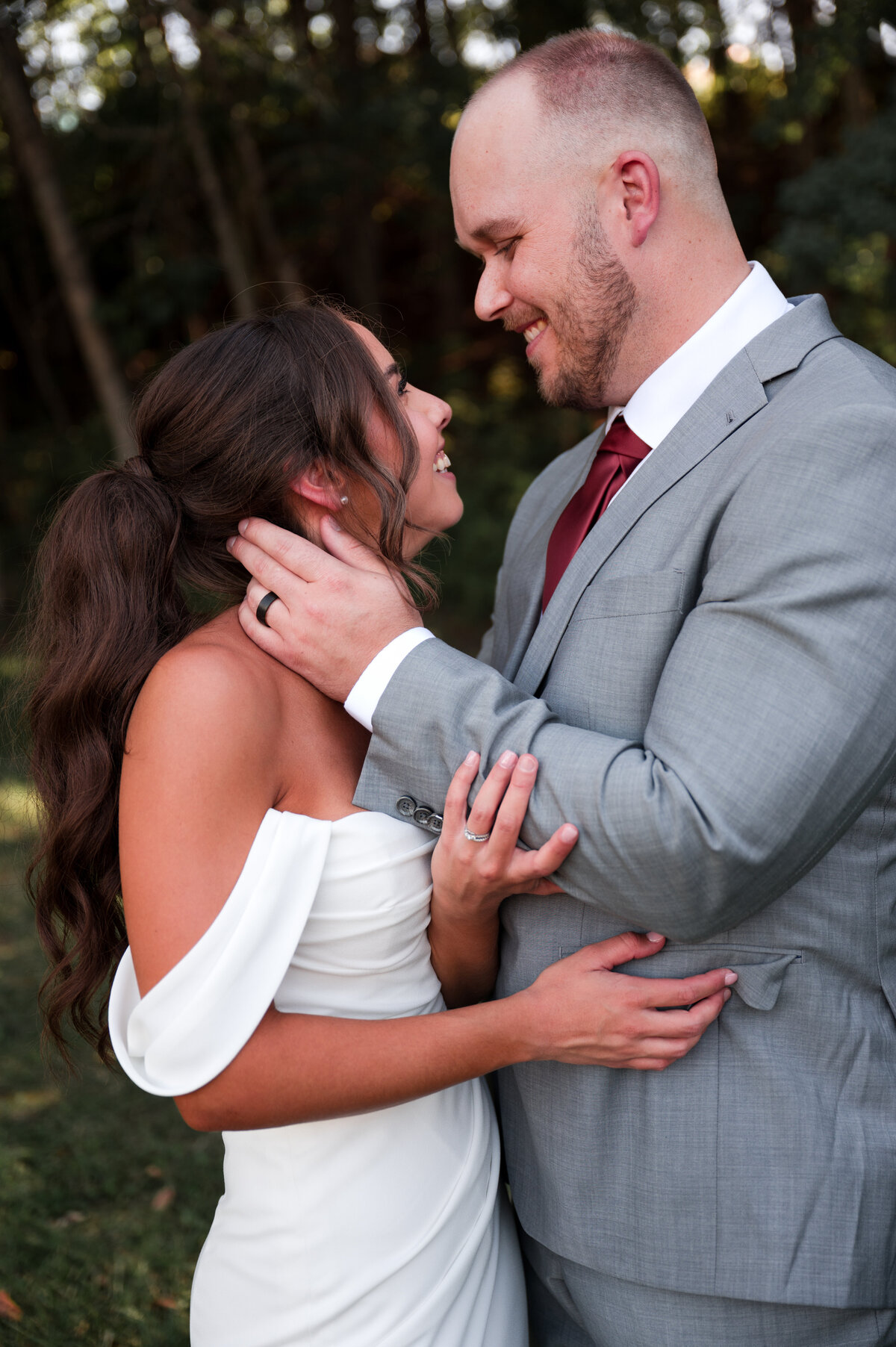 groom holding onto his brides face showing wedding rings