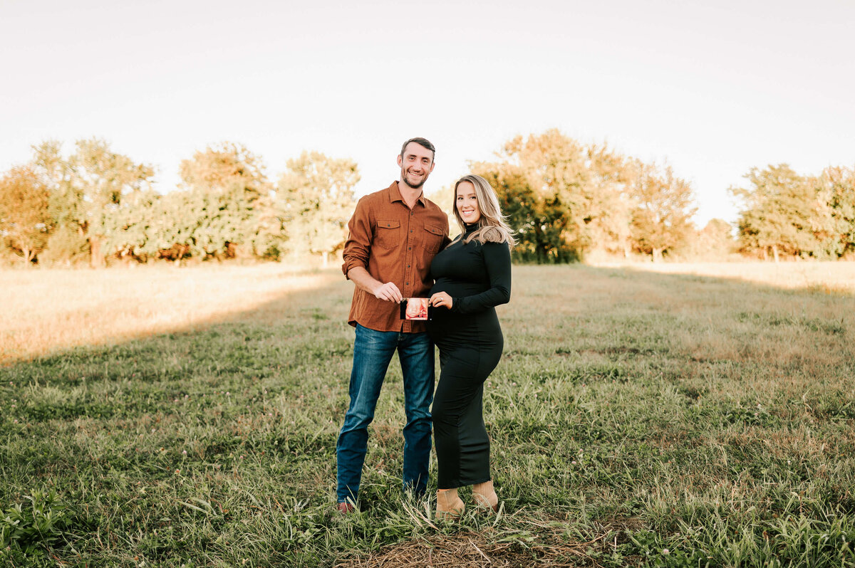 pregnant couple holding ultrasound photo during maternity photography session in Springfield MO