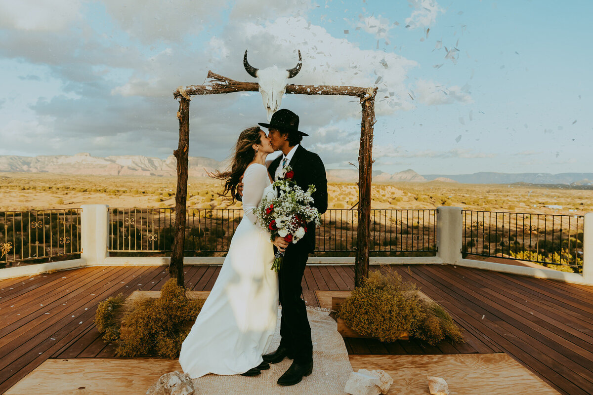 man and woman kiss as confetti falls around them in sedona arizona