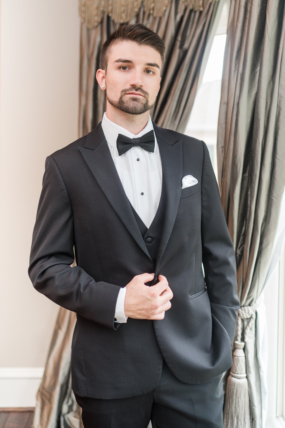 groom posing in tuxedo