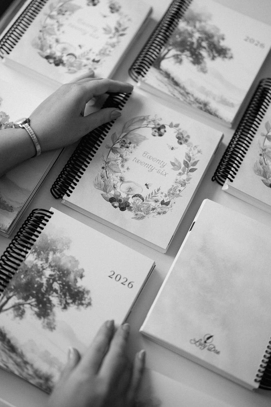 Black and white photo showing multiple planner designs being browsed during the Indiana branding session.