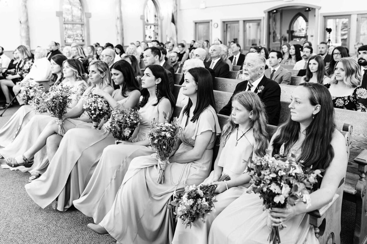 Wedding guests sitting in pews at Big Sky Chapel, Big Sky, Montana