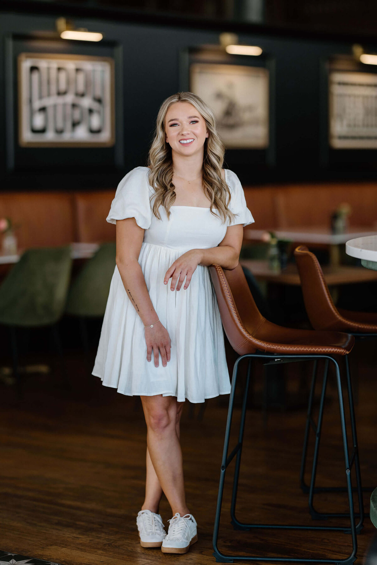 ETBU graduate in white dress posing for photoshoot