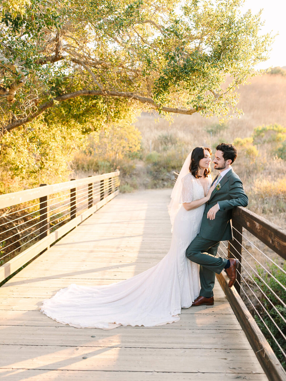 sunset wedding photography of bride and groom on a bridge with mountain view