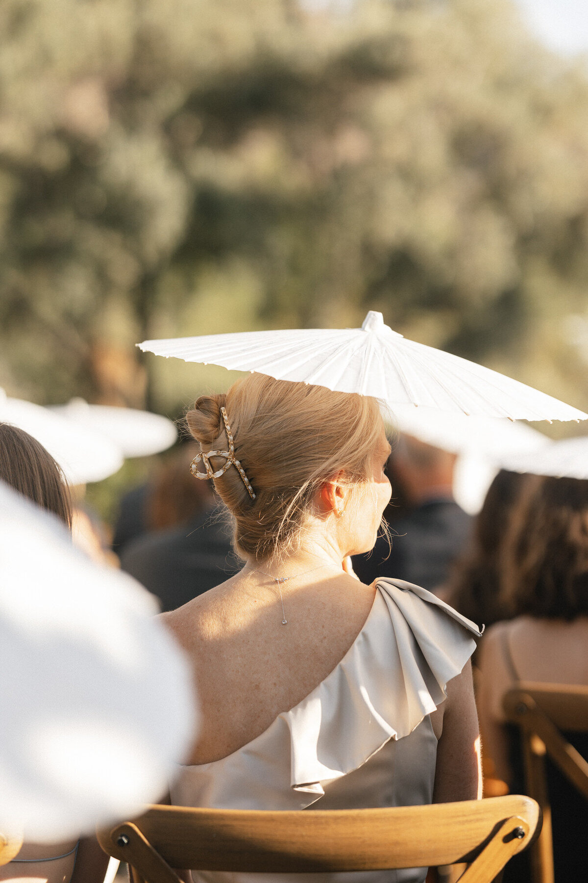 Guest holding parasol during wedding ceremony at El Chorro