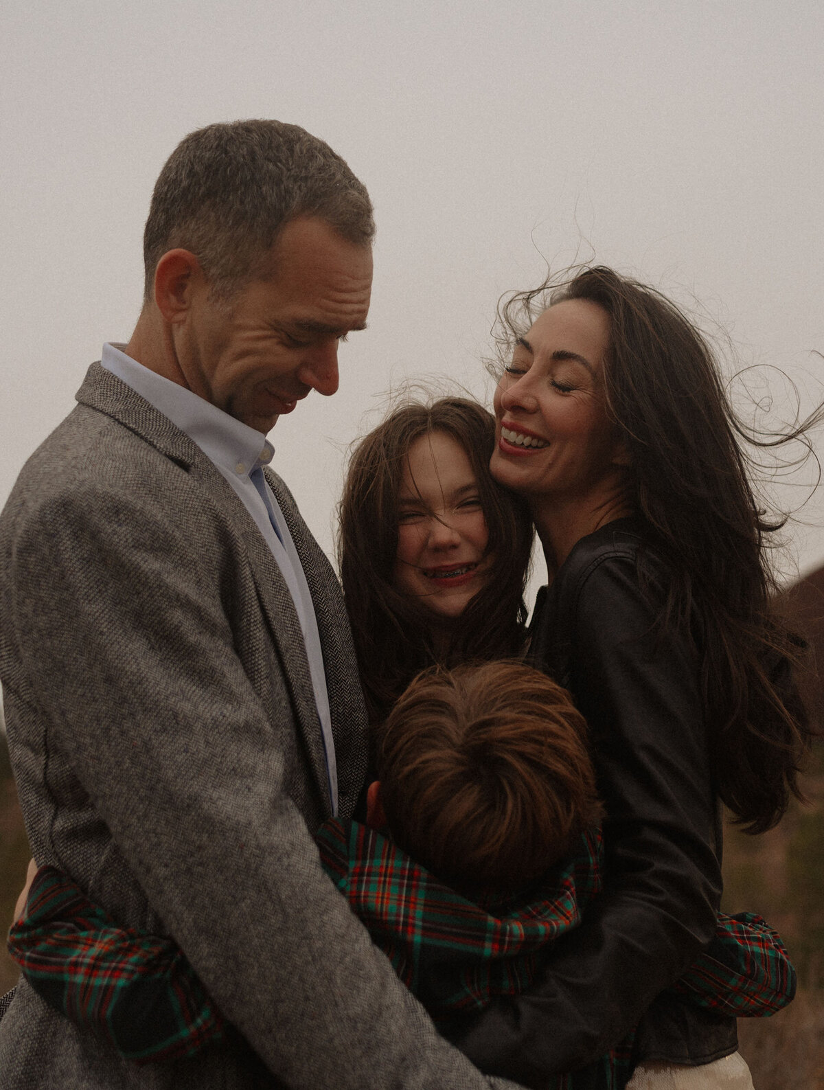 candid family photo of parents and two children laughing and playing in Bend, Oregon