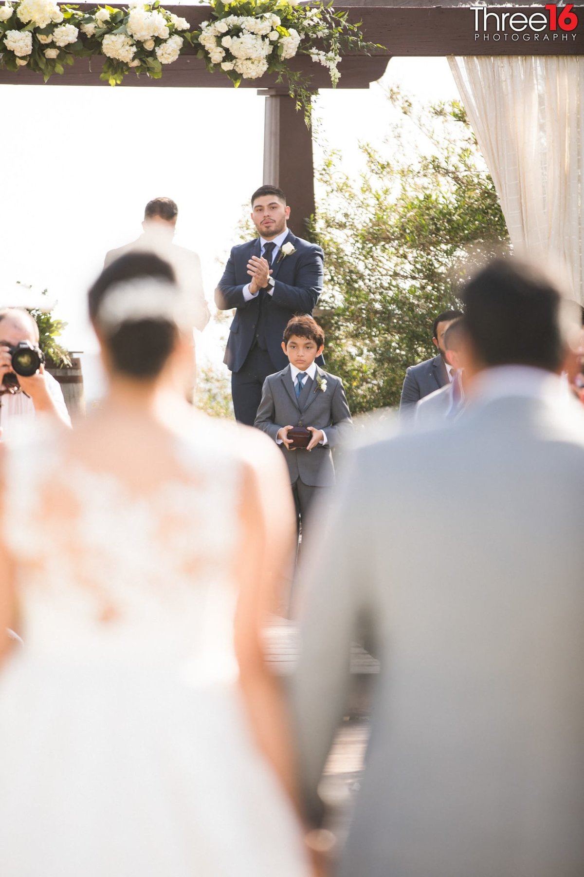 Groom waits at the altar as his Bride is being escorted up the aisle by her father
