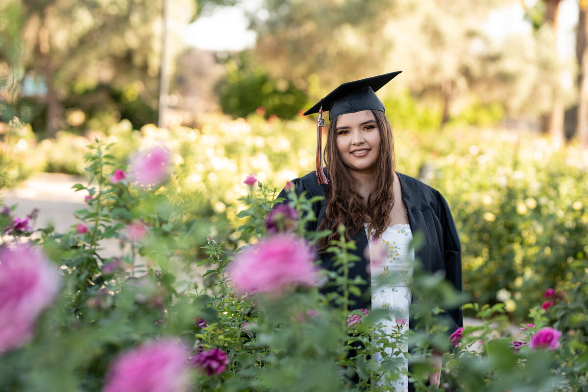 Senior girl standing in rose garden
