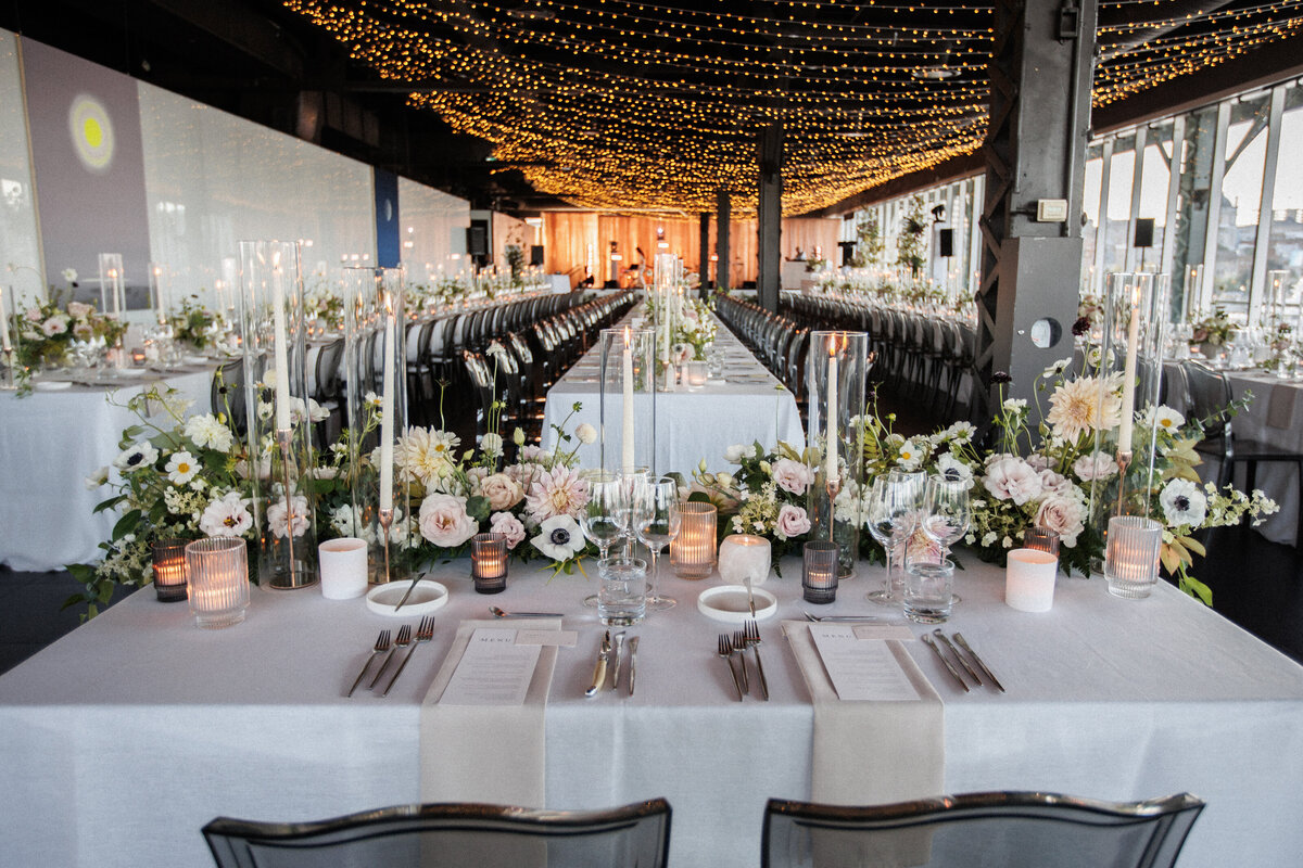 View of a Science Centre wedding reception from behind a sweetheart table lined with garden flowers