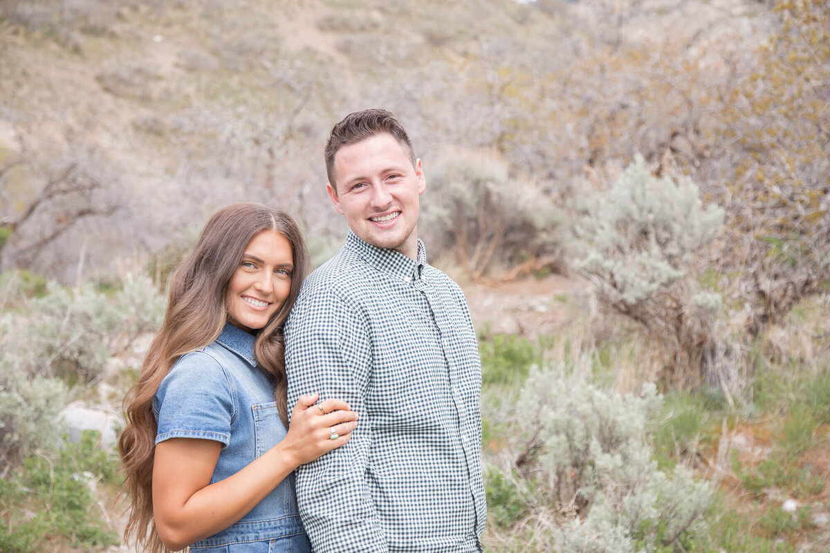 Couple in blue and green posing in front of Rock Canyon