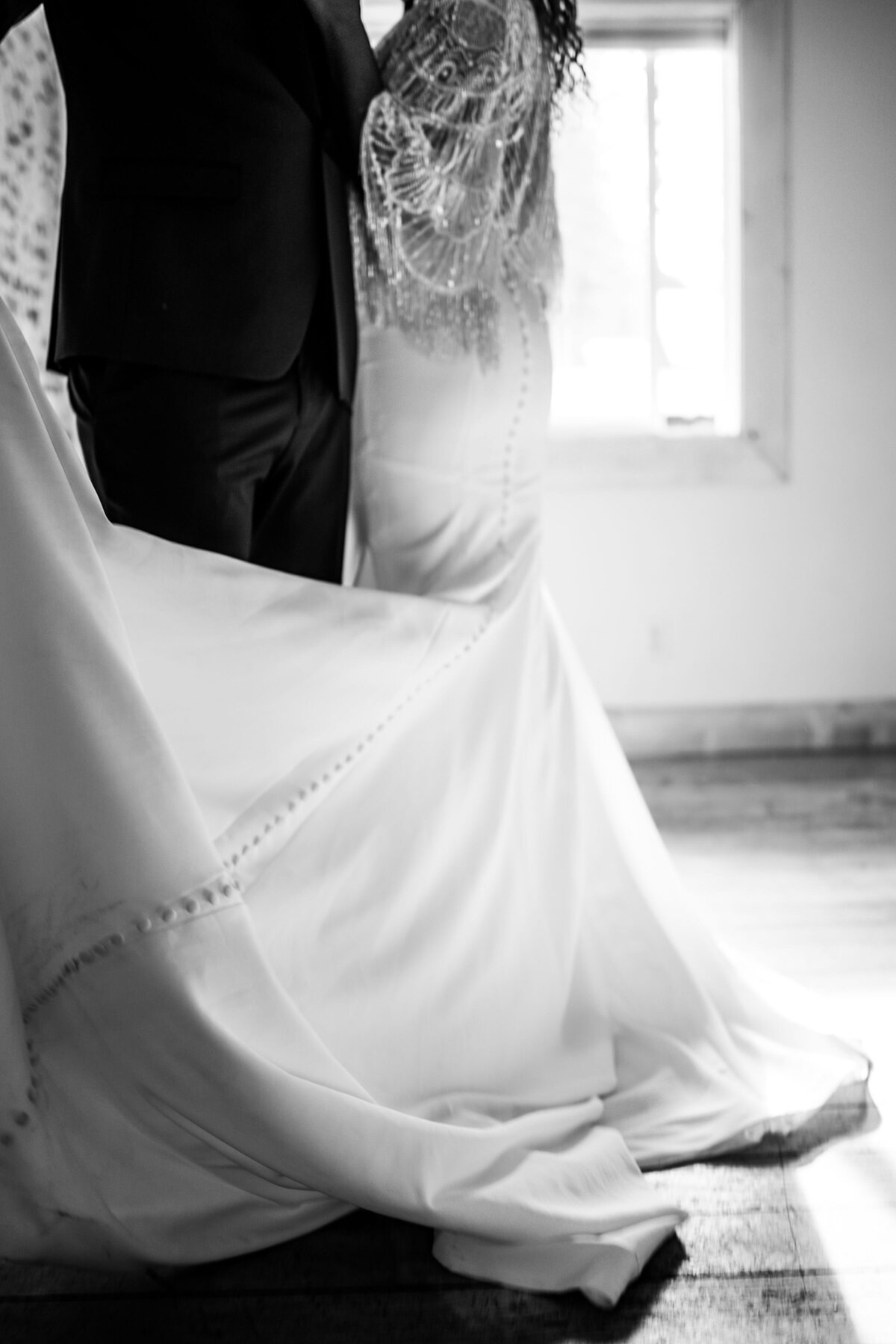Black and White photo of bottom half of bride and groom with light shining through the window captured by Idaho Falls Wedding Photographer