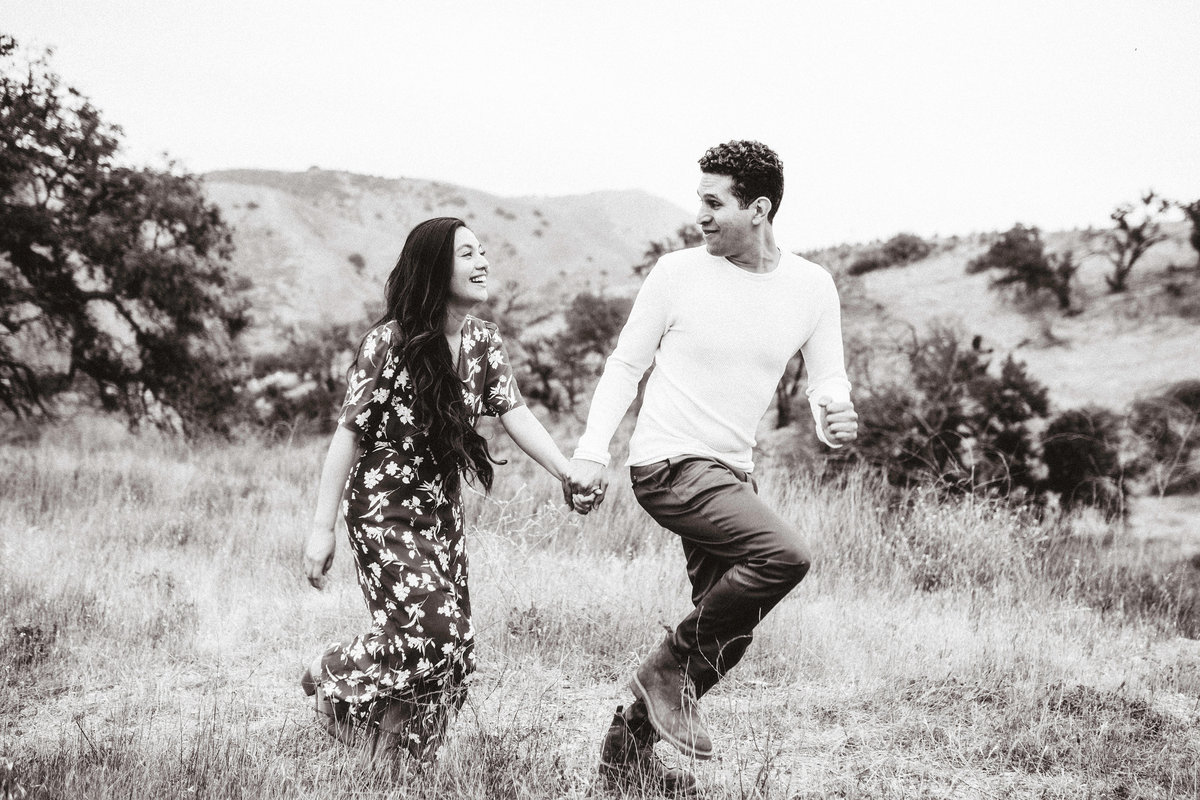 Engagement Photograph Of  Man And Woman Holding Hands While Running Los Angeles