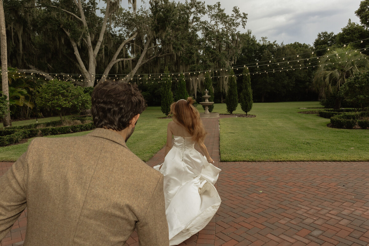 Romantic backyard wedding at The Palm Mansion in Umatilla, Florida with lush palm trees and floral arch
