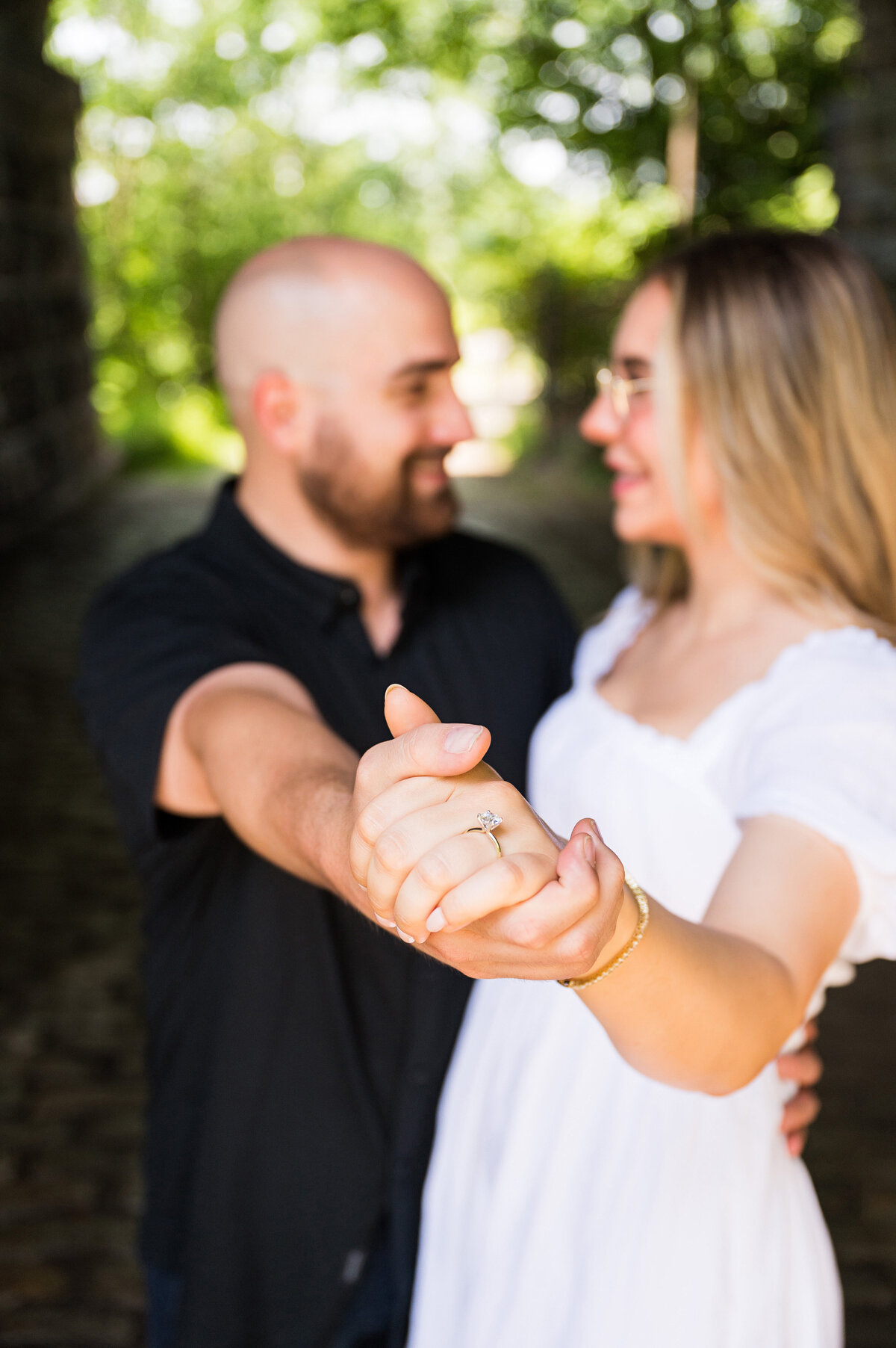 couple showing off engagement ring in proposal photo