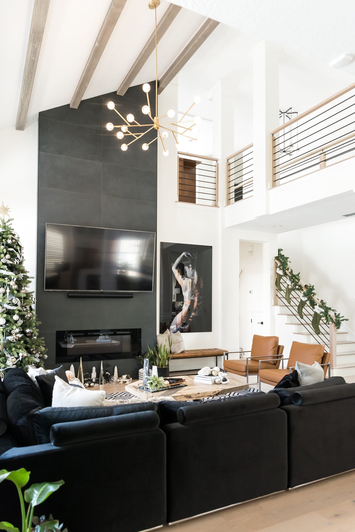 dewine design orlando interior designer modern lakehouse black sofa and vaulted ceiling with wood beams