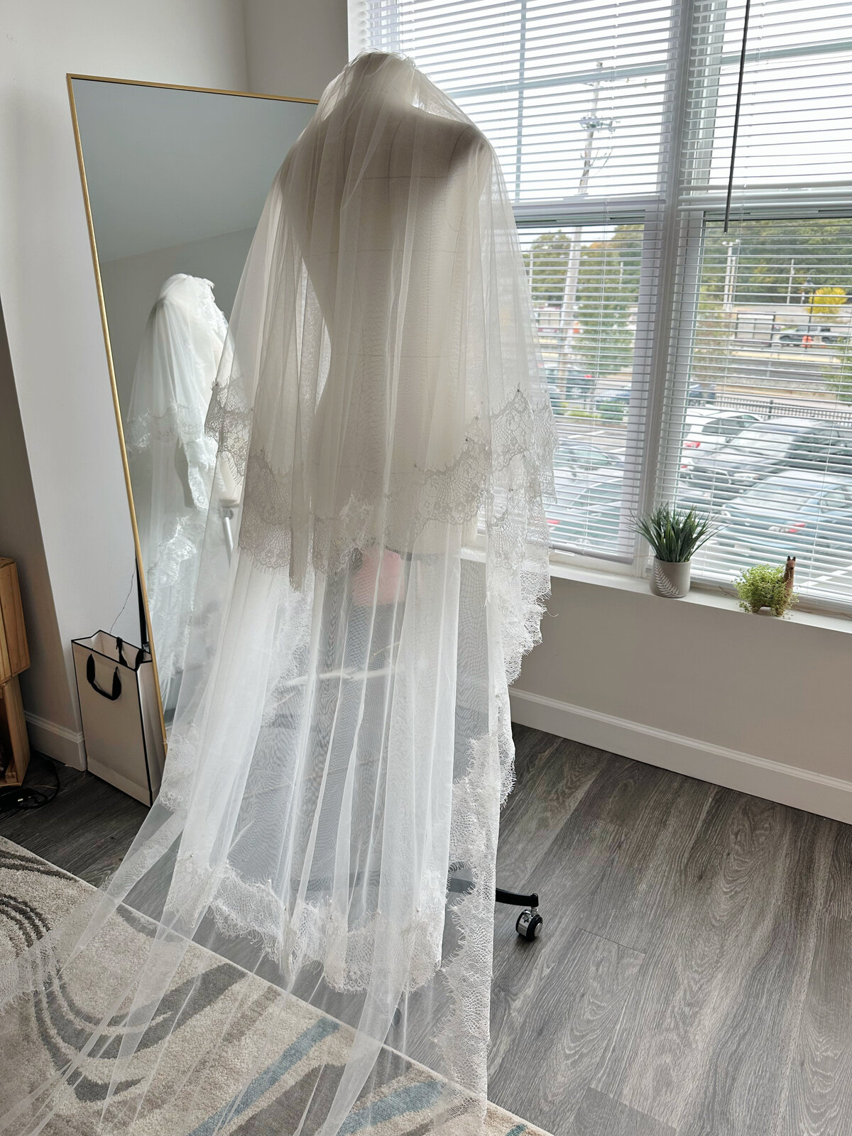 Bride holding bouquet under lace-edge blusher veil
