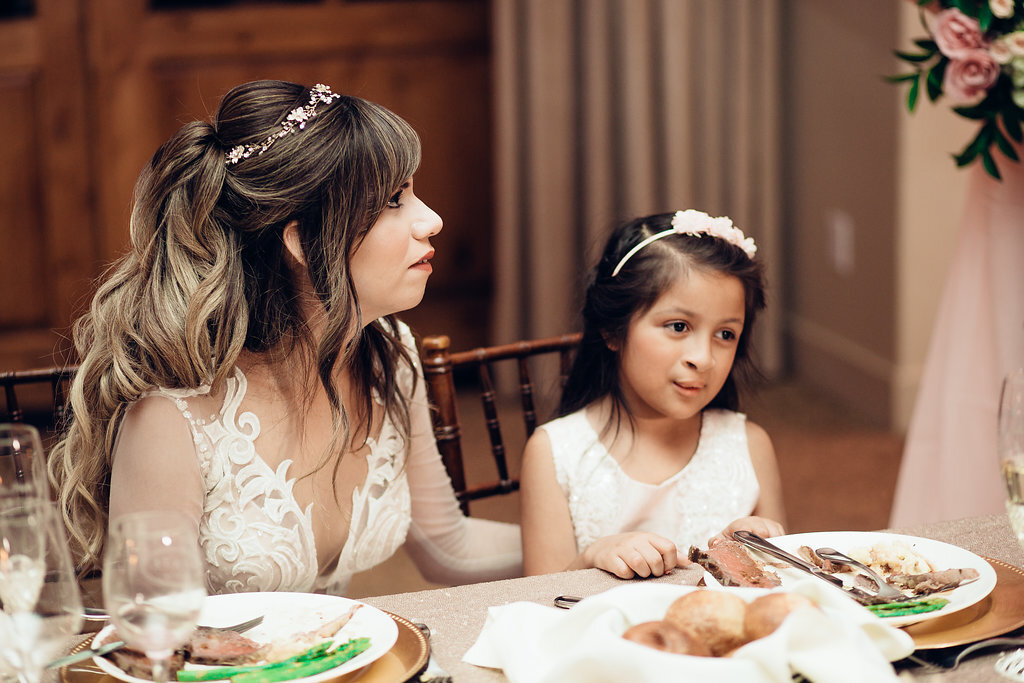 Wedding Photograph Of Bride In White Dress Sitting Beside a Kid In White Dress Los Angeles