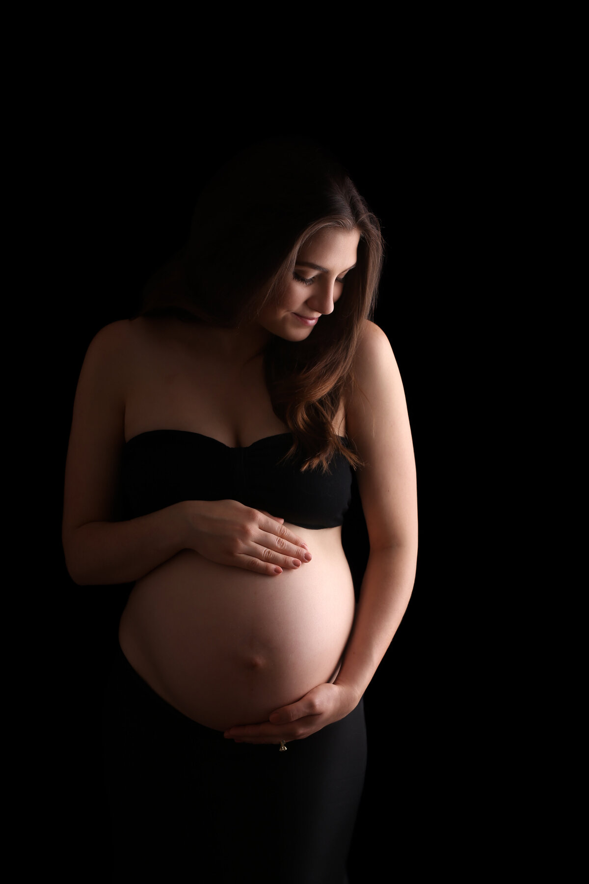Pregnant mother with her hands lovingly placed on her belly