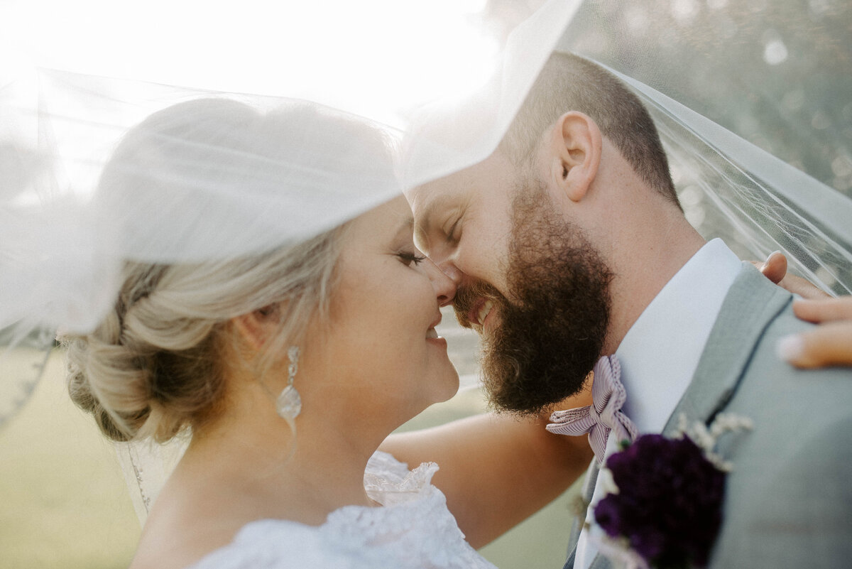 Bride and groom under veil