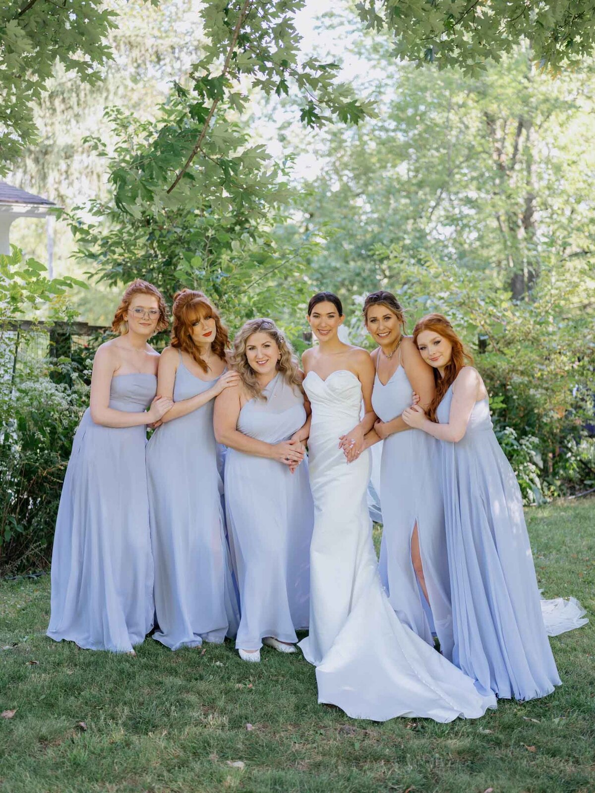Bride in Maggie Sottero gown with bridesmaids in blue Birdy Grey dresses.