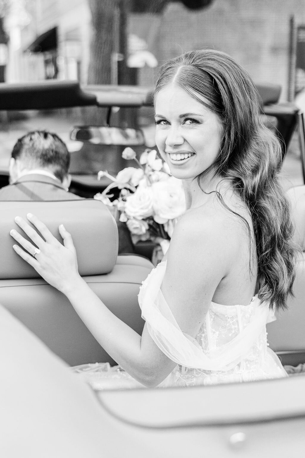 A radiant bride smiles as she departs in a classic convertible after her Charleston wedding, capturing the joy of the day.  Amia Marcell charleston wedding Photographer.