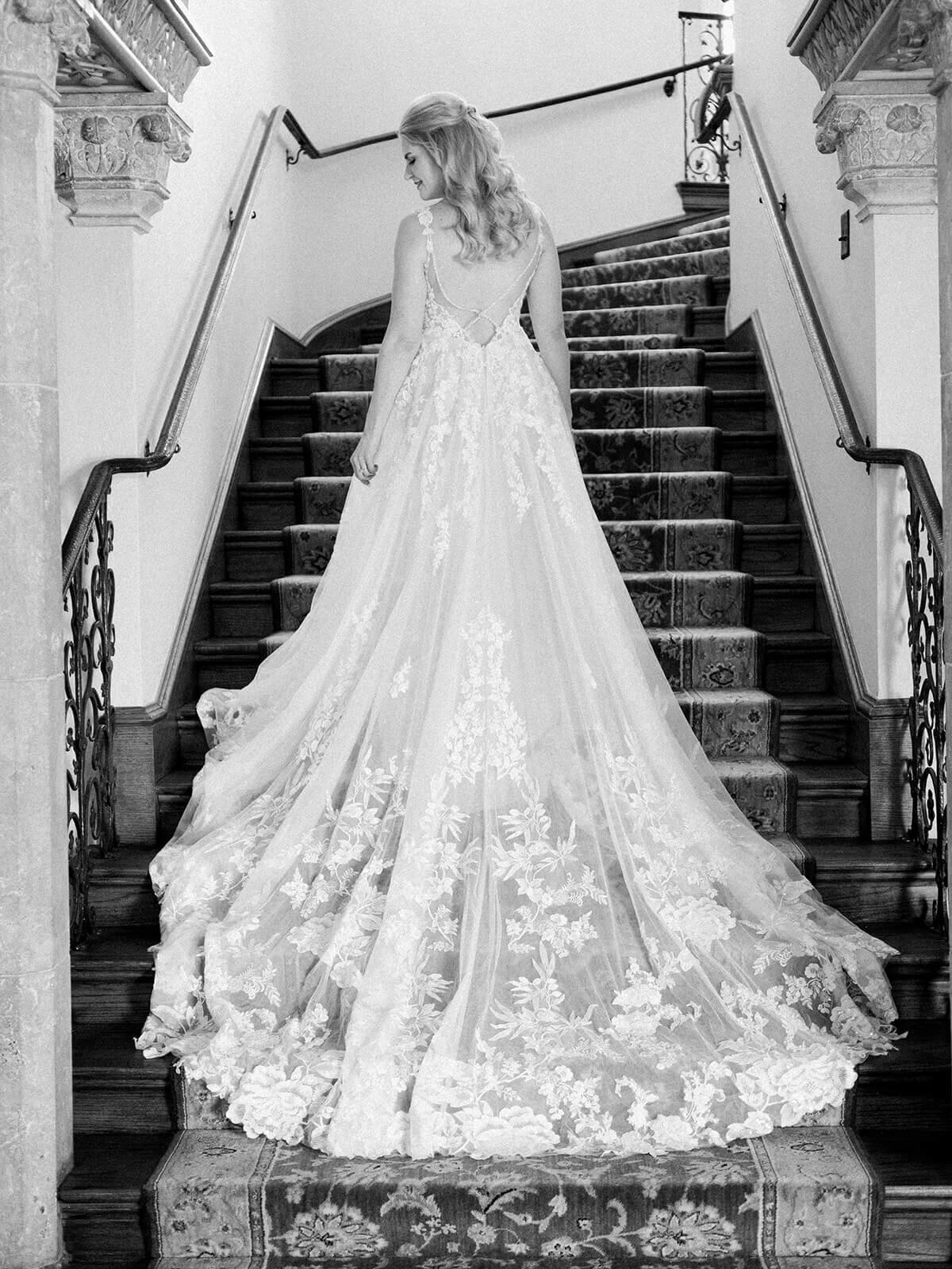 Bridal portrait standing on stairs with full wedding dress detail