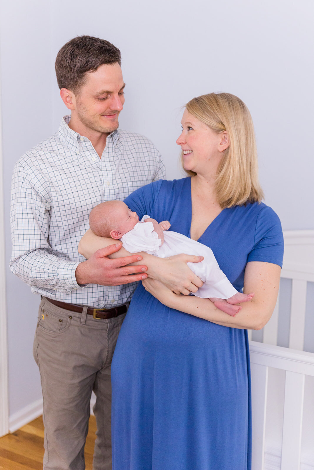 parents holding newborn baby girl and looking at each other in the nursery life style picture Laure Photography Atlanta family and newborn photographer