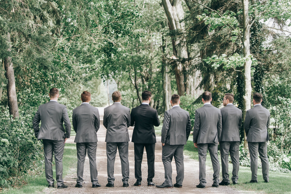Groom and groomsmen in grey attire posing for classic portraits